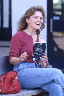 Photograph of a student smiling while reading