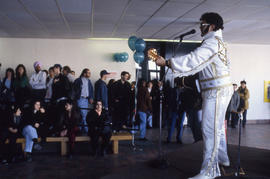 Photograph of Two People Watching an Elvis Impersonator