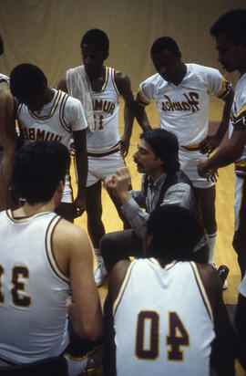 Photograph of coach talking to members of the Humber Hawks basketball team