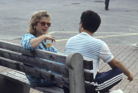 Photograph of students socializing on a bench
