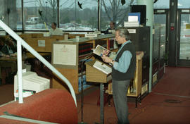 Photograph of Wayson Choy reading in the library