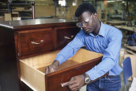 Photograph of a Student Working on a Cabinet in the Lab