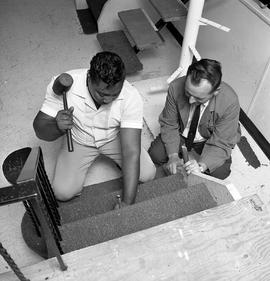 Photograph of a Carpet Laying instructor instructing a student