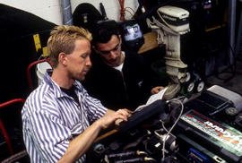 Photograph of Robert Smith and student performing engine diagnostics