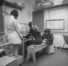 Photograph of Three Students Using a Loom