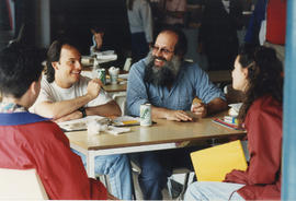 Photograph of John Steckley sitting with students in the cafeteria