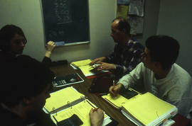 A photograph of a faculty member working with students