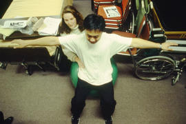 Photograph of nursing student assisting another with exercises
