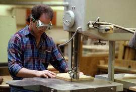 Photograph of Industrial Design student cutting wood at a band saw