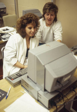 Photograph of a Journalism student typing an article into a computer