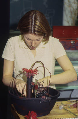 A photograph of a Retail Floriculture student building a floral arrangement