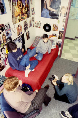 Photograph of students seated and chatting in a residence dorm