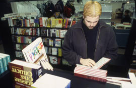 A photograph of a student browsing books in the Bookstore