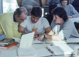 Photograph of a faculty member assisting students with their assignment