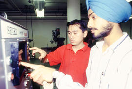 Photograph of students operating a control panel