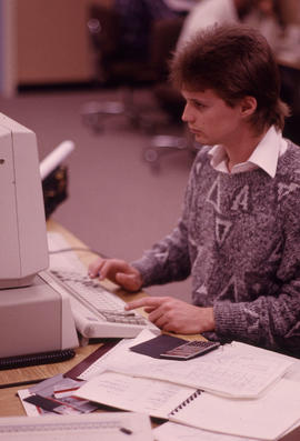 Photograph of a person seated infront of a computer