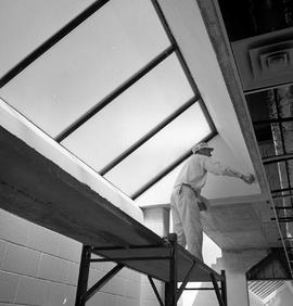 Photograph of a plasterer working inside the D-building