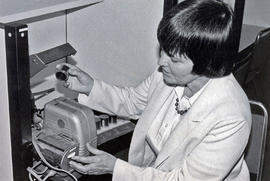 Photograph of Peggy Eiler Using a Film Strip Reader in the Library