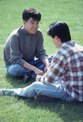 Photograph of Two Students Chatting on the Grass