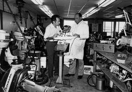 Photograph of George Kay and Unknown Working on a Marine Outboard Motor