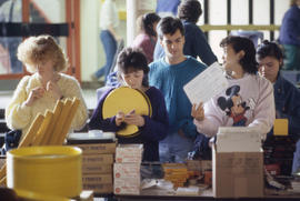 Photograph of persons standing at a table with books