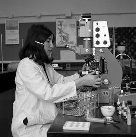 Photograph of a Lab Technician student using a microscope