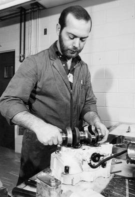 Photograph of a technology student working on an engine