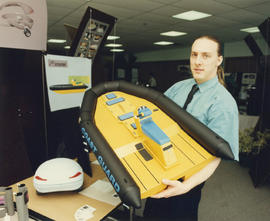 Photograph of an Industrial Design student with a model of their design