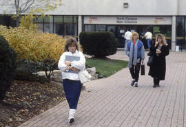 Photograph of unknown people walking on the corridor at North