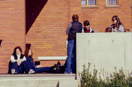 Photograph of students sitting on the walkway at Lakeshore