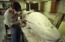 A photograph of an Industrial Design student sanding his design model
