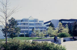 Photograph of of the NX building and students seated outside