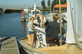 Two students on Sailing School boat by the water : [photograph]