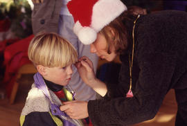 Photograph of a Kid Getting Their Face Painted During the Christmas Tree Sale and Family Event