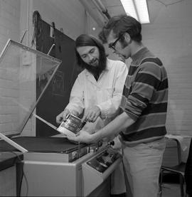 Photograph of Bob Day working with a student at an exposure machine