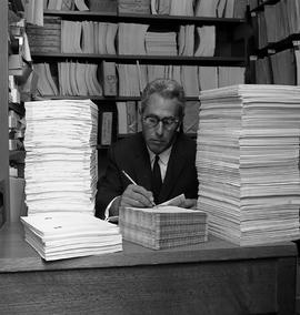 Photograph of Sam Preston framed around books he prepared for his Technical Writing program