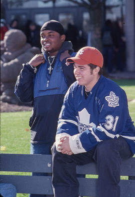 Photograph of two students posing closely to a sculpture