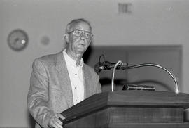 Photograph of Eric Wright speaking at a podium during a creative writing workshop