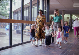 Photograph of ECE staff with children in the hallway
