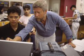 Photograph of instructor Ed Vokurka instructing student in electronics lab