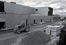 Photograph of a Worker Driving a Lift Truck Next to the Construction of the Complex 5