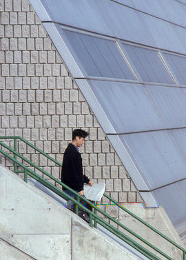 Photograph of a student exiting a building through an outdoor stairwell