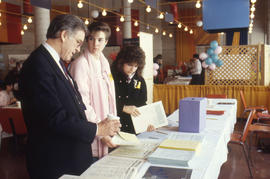 Photograph of persons looking through some documents