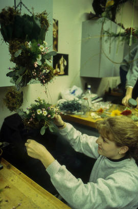 A photograph of a Retail Floriculture student building an arragement