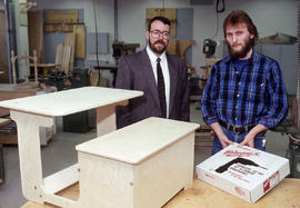Photograph of a student standing next to their completed woodworking project