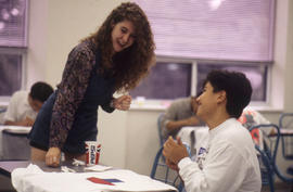 Photograph of a Student Working on Painted T-Shirt Designs