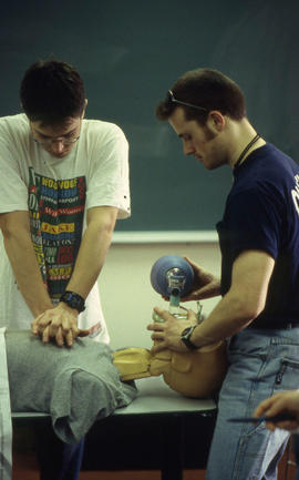 A photograph of two Emergency Skills program students practicing on a CPR dummy
