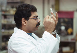 Photograph of a Medical student examining a vial