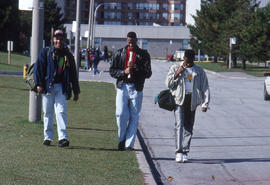 Photograph of students walking by the main road by the parking kiosk