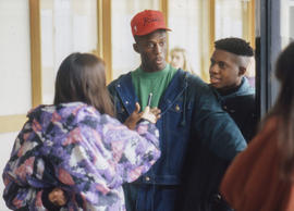 Photograph of two students being interviewed in the hall by a Journalism student